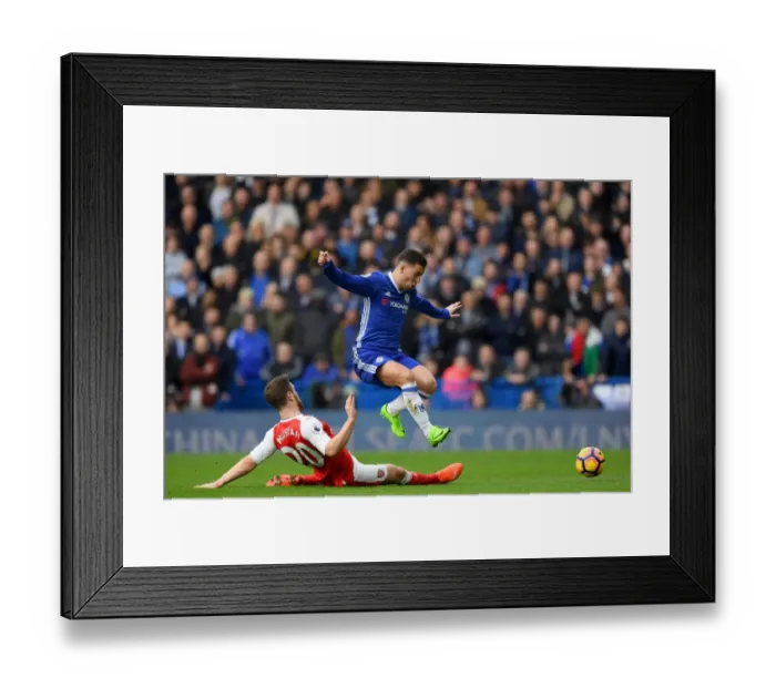 Framed Print : Hazard's Leap Over Mustafi: Intense Rivalry in Chelsea vs Arsenal Premier League Showdown