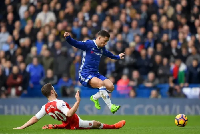 Framed Print : Hazard's Leap Over Mustafi: Intense Rivalry in Chelsea vs Arsenal Premier League Showdown
