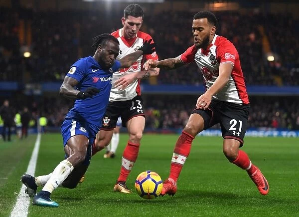 Intense Battle for Possession: Chelsea's Victor Moses vs. Southampton's Ryan Bertrand and Pierre-Emile Hojbjerg