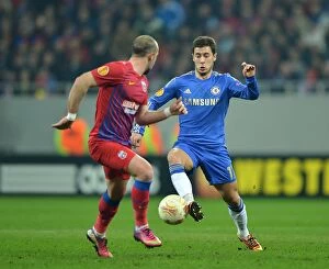 Images Dated 7th March 2013: Hazard vs. Latovlevici: A Battle for Ball Possession - Chelsea vs. Steaua Bucharest